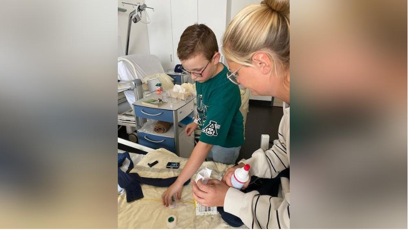 Kind wird im Umgang mit Insulinpumpe geschult