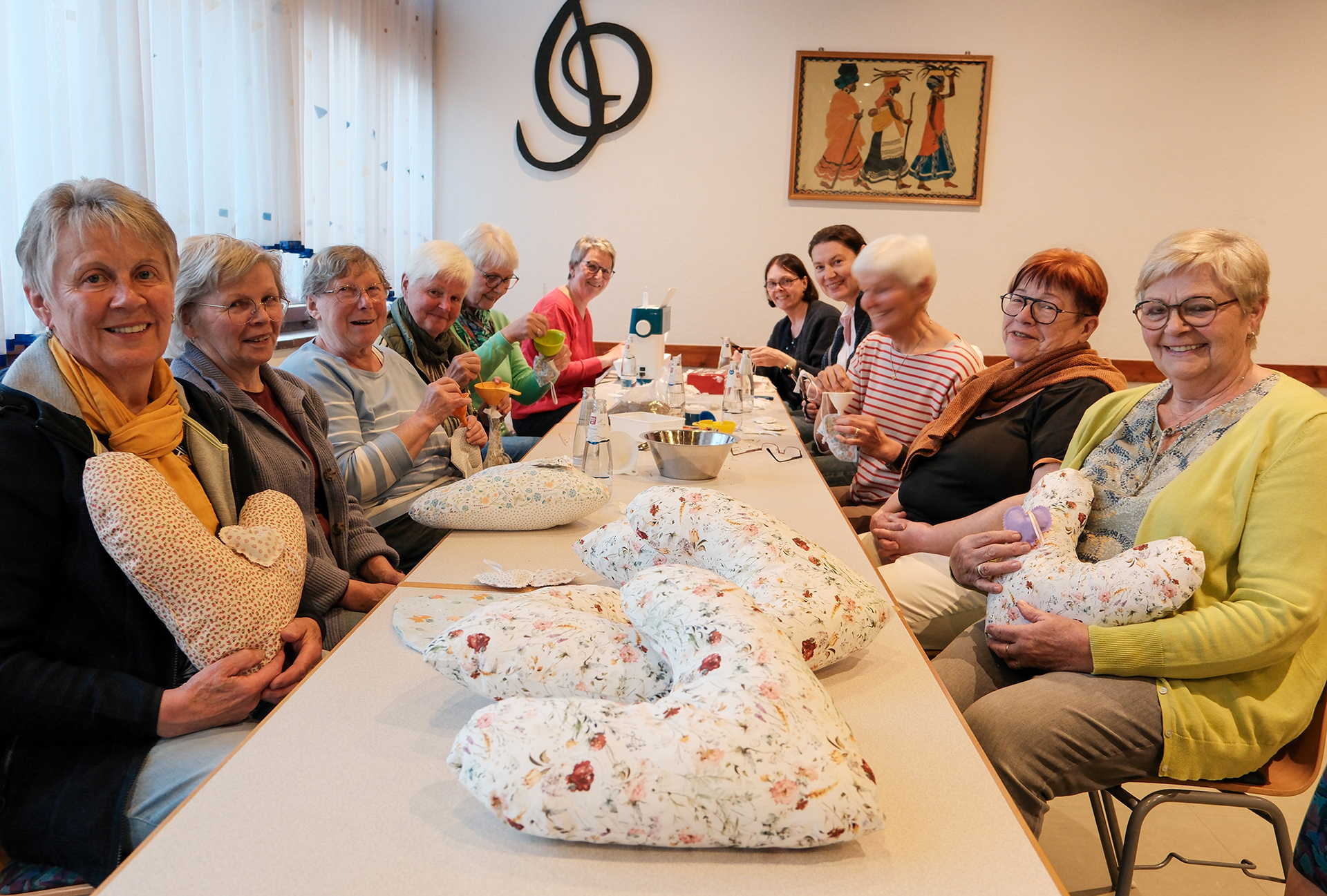 Viele Damen, die an einem Tisch sitzen und in die Kamera lächeln