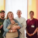 Mutter und Vater mit neugeborenem Sohn Oskar feiern gemeinsam mit Mitarbeitenden der Main-Kinzig-Kliniken die 1000. Geburt des Jahres 2025