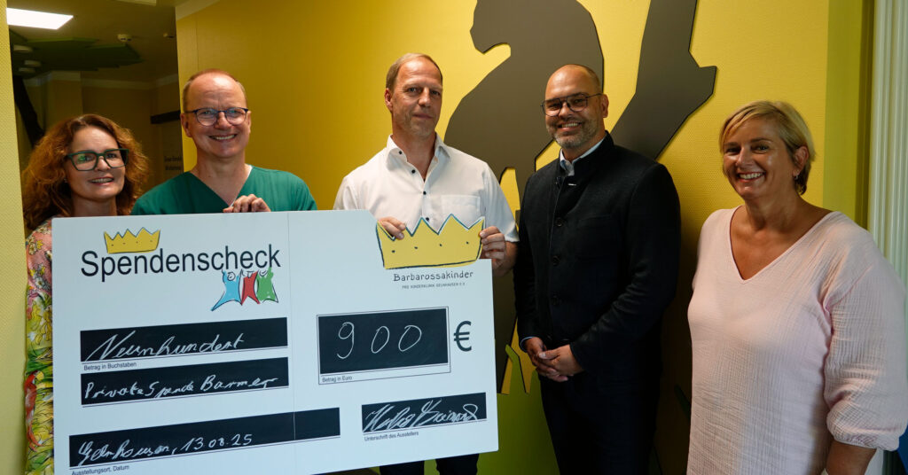Barmer-Mitarbeitende übergeben Spendencheck mit Blutspendenaktionserlös an Barbarossakinder.